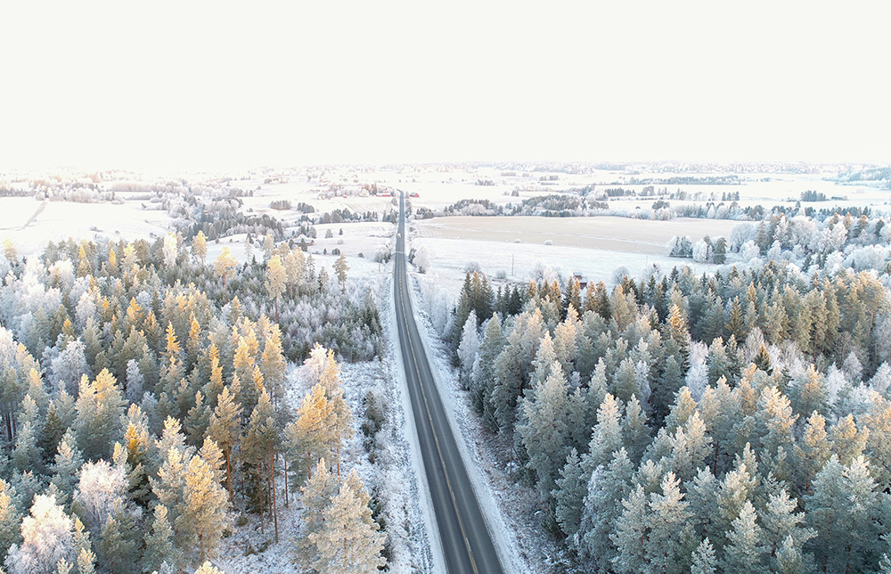 Talvinen maisema, keskellä kulkee tie.